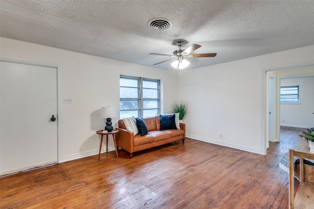 7612 Oxley Dr, Richland Hills, TX 76118 - living area featuring wood finished floors, healthy amount of natural light, ceiling fan, a textured ceiling, and baseboards