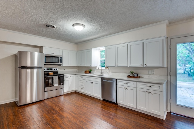 7612 Oxley Dr, Richland Hills, TX 76118 - kitchen with stainless steel appliances, a sink, a textured ceiling, ornamental molding, and light countertops