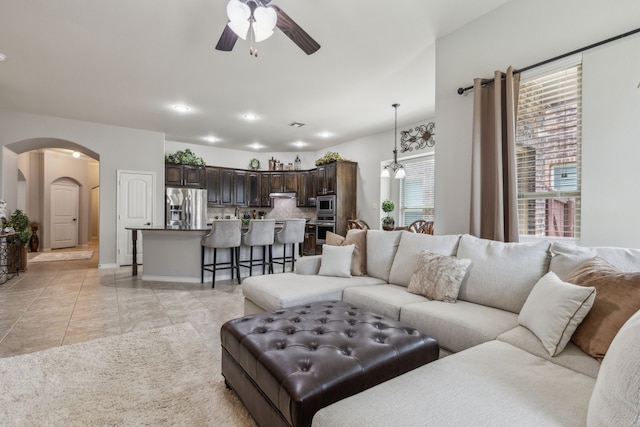 10420 Old Eagle River Ln, Mckinney, TX 75072 - living room with arched walkways, a ceiling fan, light tile patterned floors, and baseboards