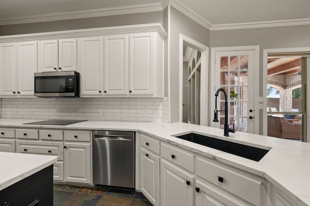 840 Falcon Ln, Coppell, TX 75019 - kitchen featuring appliances with stainless steel finishes, a sink, stone tile flooring, backsplash, and ornamental molding