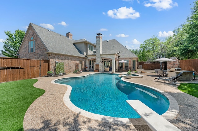 840 Falcon Ln, Coppell, TX 75019 - view of pool with a patio area, a pool with connected hot tub, an outdoor kitchen, and a diving board