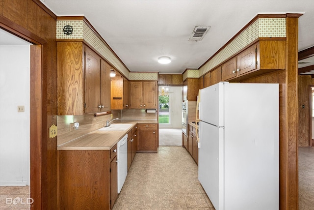 4404 Curtis Loop, Bossier City, LA 71112 - kitchen with white appliances, brown cabinets, light countertops, a sink, and ornamental molding