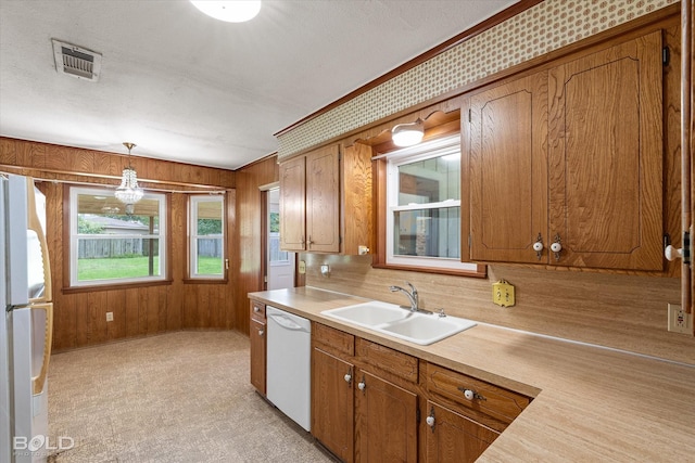 4404 Curtis Loop, Bossier City, LA 71112 - kitchen featuring white appliances, a sink, a chandelier, brown cabinetry, and wooden walls