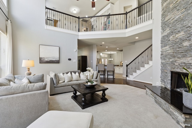 4104 Navarro Way, Frisco, TX 75034 - carpeted living room with ceiling fan, stairs, a high ceiling, a fireplace, and recessed lighting