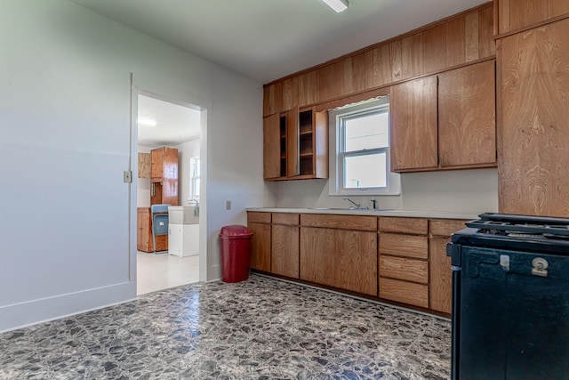 732 N Patrick St, Dublin, TX 76446 - kitchen with gas range oven, a sink, brown cabinetry, and light countertops