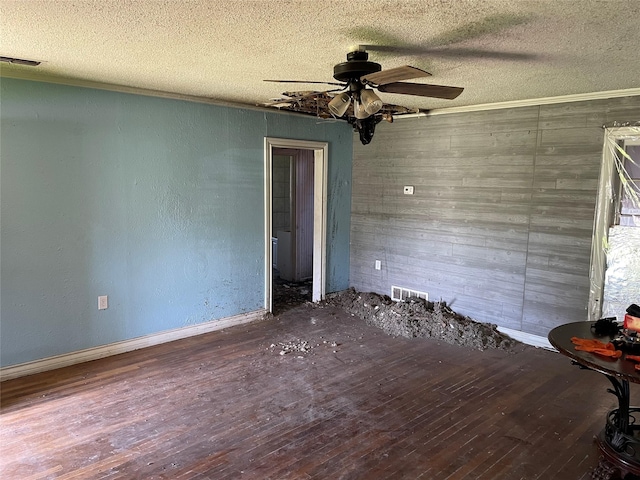 601 N Newsom St, Mineola, TX 75773 - empty room featuring wood finished floors, a ceiling fan, a textured ceiling, wood walls, and baseboards