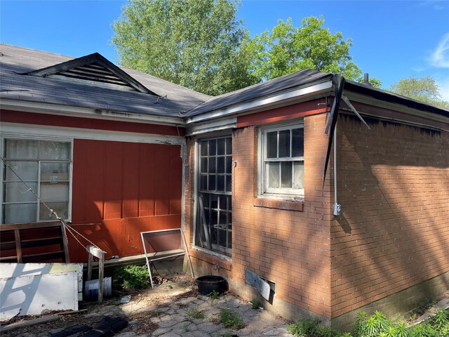 601 N Newsom St, Mineola, TX 75773 - view of side of property featuring brick siding, roof with shingles, and crawl space