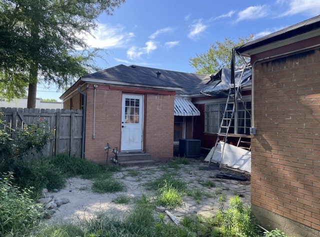 601 N Newsom St, Mineola, TX 75773 - back of house with entry steps, central AC, brick siding, and a shingled roof