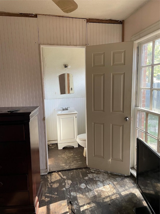 601 N Newsom St, Mineola, TX 75773 - bathroom with wood walls, toilet, and vanity