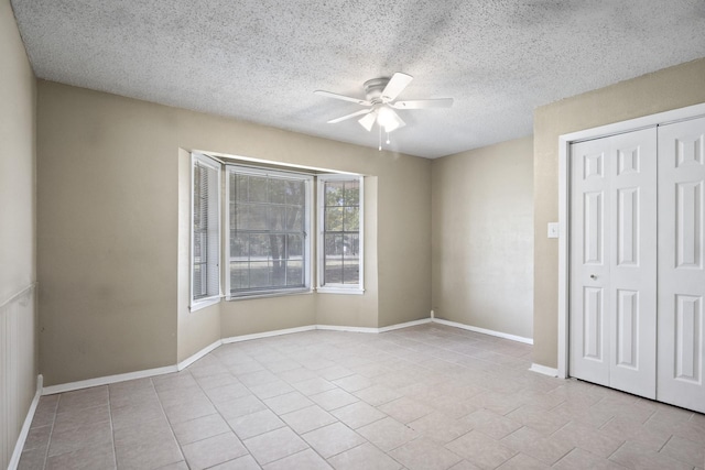 5161 N Hwy 271, Pittsburg, TX 75686 - unfurnished bedroom with tile patterned floors, a closet, a textured ceiling, a ceiling fan, and baseboards
