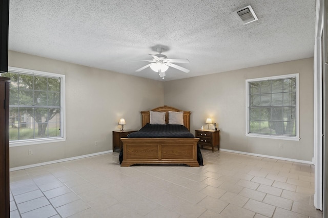 5161 N Hwy 271, Pittsburg, TX 75686 - bedroom featuring light tile patterned flooring, baseboards, a textured ceiling, and a ceiling fan