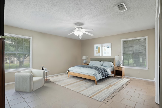 5161 N Hwy 271, Pittsburg, TX 75686 - bedroom with multiple windows, baseboards, light tile patterned flooring, a textured ceiling, and ceiling fan