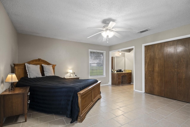 5161 N Hwy 271, Pittsburg, TX 75686 - bedroom with a textured ceiling, light tile patterned floors, baseboards, ensuite bath, and a ceiling fan