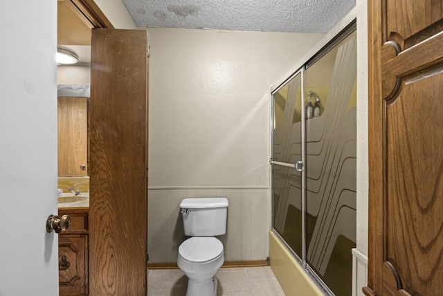 5161 N Hwy 271, Pittsburg, TX 75686 - full bathroom with toilet, a textured ceiling, vanity, combined bath / shower with glass door, and wainscoting