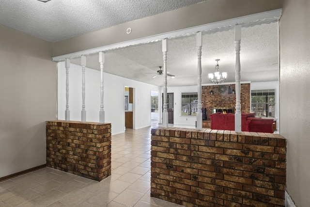 5161 N Hwy 271, Pittsburg, TX 75686 - kitchen with a textured ceiling, a brick fireplace, a ceiling fan, tile patterned flooring, and baseboards