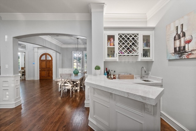 7000 Shalimar Ct, Colleyville, TX 76034 - kitchen with arched walkways, a sink, dark wood-style flooring, crown molding, and white cabinetry