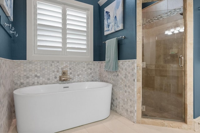 7000 Shalimar Ct, Colleyville, TX 76034 - bathroom featuring a freestanding bath, wainscoting, tile walls, a stall shower, and tile patterned flooring