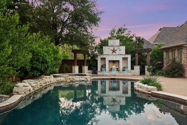 7000 Shalimar Ct, Colleyville, TX 76034 - pool at dusk featuring an outdoor stone fireplace, a patio area, and a pool with connected hot tub