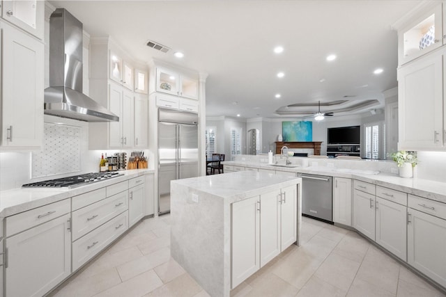 7000 Shalimar Ct, Colleyville, TX 76034 - kitchen with stainless steel appliances, wall chimney exhaust hood, ceiling fan, a peninsula, and open floor plan