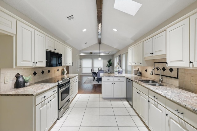 2420 Cross Timbers Trl, Arlington, TX 76006 - kitchen with stainless steel appliances, a sink, white cabinetry, a skylight, and a peninsula