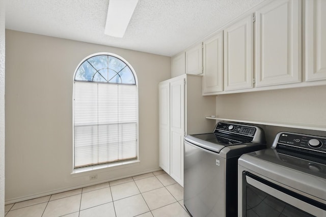 2420 Cross Timbers Trl, Arlington, TX 76006 - laundry room featuring washing machine and dryer, cabinet space, a textured ceiling, and light tile patterned floors
