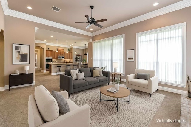 520 Canterbury Ln, Bossier City, LA 71111 - living room featuring arched walkways, light colored carpet, a ceiling fan, baseboards, and ornamental molding