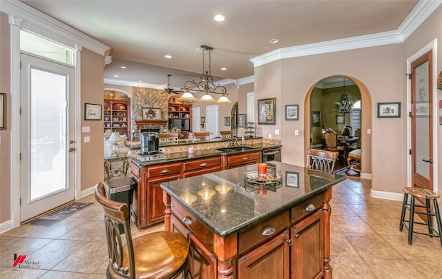520 Canterbury Ln, Bossier City, LA 71111 - kitchen with light tile patterned floors, arched walkways, brown cabinets, a sink, and ornamental molding