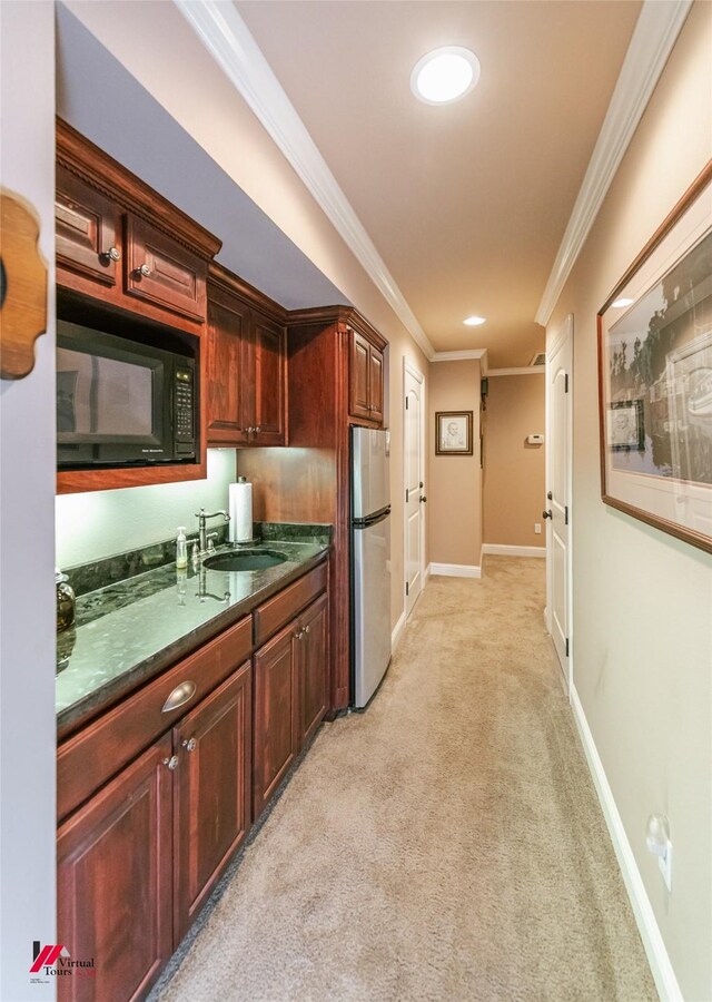 520 Canterbury Ln, Bossier City, LA 71111 - kitchen featuring freestanding refrigerator, black microwave, a sink, crown molding, and light carpet