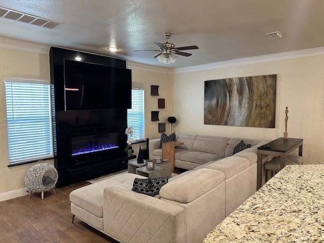 749 Ranch Rd, Fort Worth, TX 76131 - living room with ceiling fan, crown molding, plenty of natural light, wood finished floors, and a glass covered fireplace
