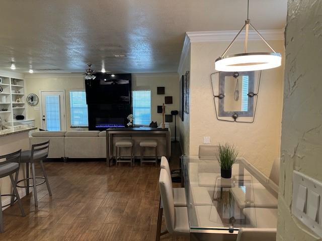 749 Ranch Rd, Fort Worth, TX 76131 - dining space with ornamental molding, dark wood-type flooring, ceiling fan, and a textured wall