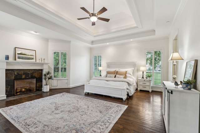 1850 Hammerly Dr, Fairview, TX 75069 - bedroom with a raised ceiling, dark wood-style floors, a tiled fireplace, ceiling fan, and crown molding