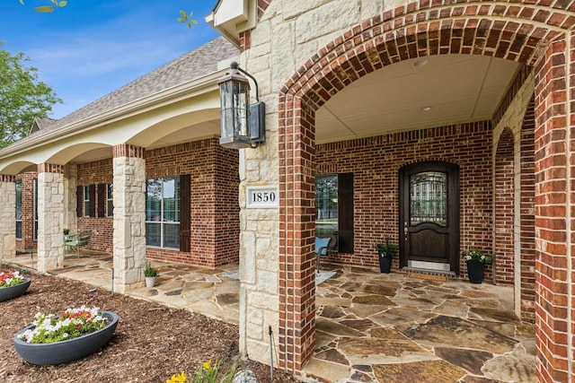 1850 Hammerly Dr, Fairview, TX 75069 - property entrance with brick siding, a shingled roof, and a porch