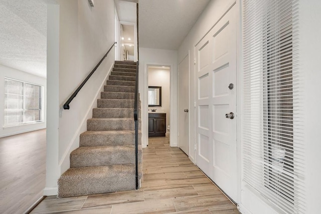 1822 Highbrook Ct, Garland, TX 75044 - stairway with wood finished floors, a textured ceiling, a heating unit, and baseboards