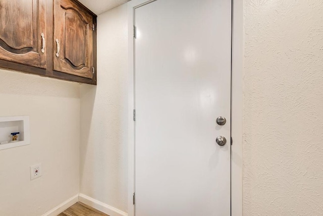 1822 Highbrook Ct, Garland, TX 75044 - laundry room with baseboards, hookup for a washing machine, cabinet space, and light wood-style floors