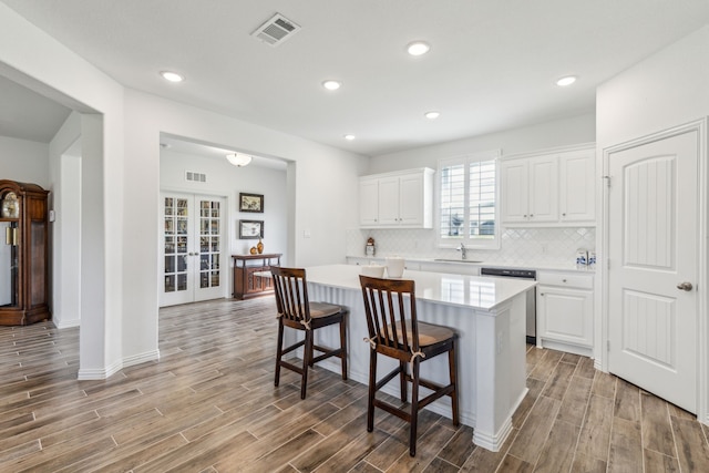2410 Blackjack Oak Rd, Oak Ridge, TX 75161 - kitchen with dishwasher, a sink, light wood-type flooring, light countertops, and white cabinetry