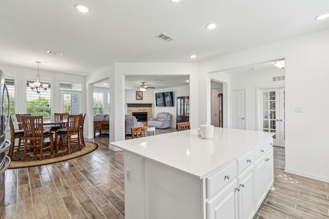 2410 Blackjack Oak Rd, Oak Ridge, TX 75161 - kitchen featuring a fireplace, light wood-type flooring, white cabinetry, light countertops, and recessed lighting