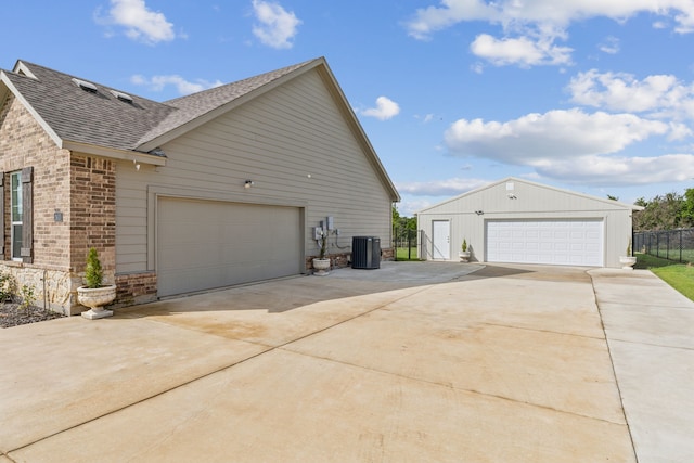 2410 Blackjack Oak Rd, Oak Ridge, TX 75161 - view of home's exterior featuring a shingled roof, brick siding, a detached garage, cooling unit, and stone siding
