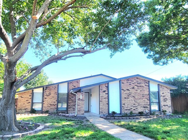 3402 Jones Dr, Rowlett, TX 75088 - mid-century inspired home with brick siding, a front lawn, and cooling unit