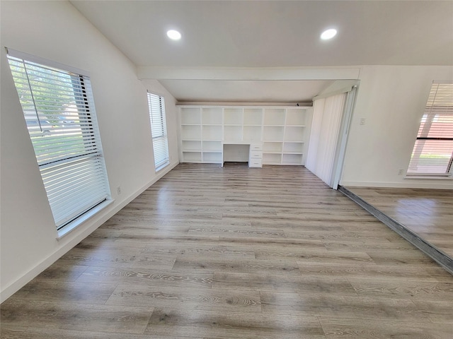 3402 Jones Dr, Rowlett, TX 75088 - unfurnished living room featuring lofted ceiling, plenty of natural light, wood finished floors, recessed lighting, and baseboards