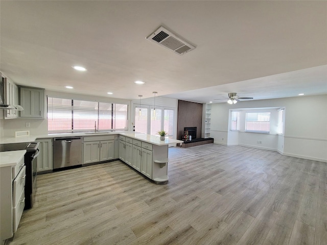 3402 Jones Dr, Rowlett, TX 75088 - kitchen featuring stainless steel dishwasher, range with electric cooktop, a sink, a peninsula, and light wood-type flooring