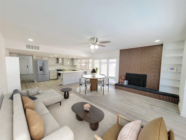 3402 Jones Dr, Rowlett, TX 75088 - living area featuring ceiling fan, light wood-style flooring, a fireplace with raised hearth, and recessed lighting
