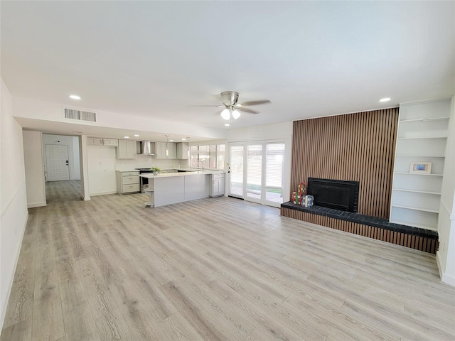3402 Jones Dr, Rowlett, TX 75088 - unfurnished living room featuring ceiling fan, a fireplace with raised hearth, light wood-type flooring, recessed lighting, and baseboards