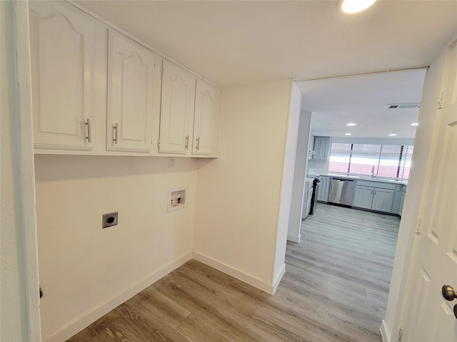 3402 Jones Dr, Rowlett, TX 75088 - washroom with electric dryer hookup, cabinet space, washer hookup, light wood-style flooring, and baseboards