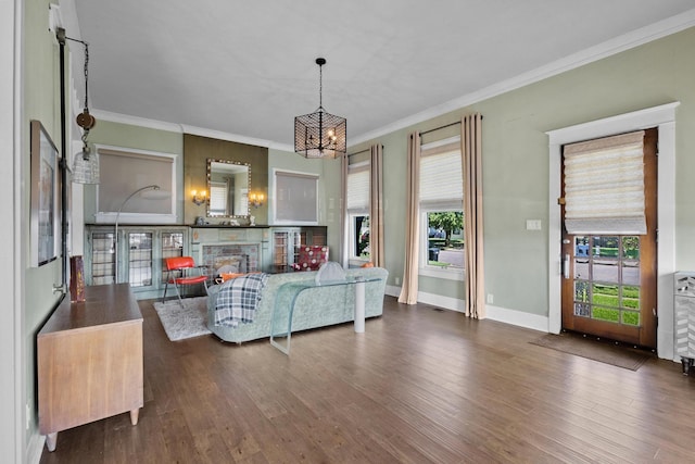 610 W Chestnut St, Denison, TX 75020 - living area with a chandelier, dark wood finished floors, crown molding, baseboards, and a stone fireplace