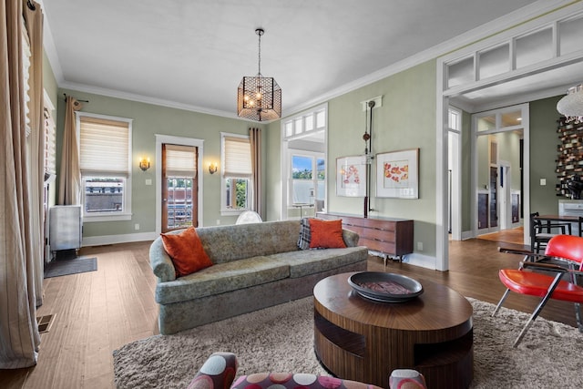 610 W Chestnut St, Denison, TX 75020 - living room featuring a chandelier, wood finished floors, baseboards, and crown molding