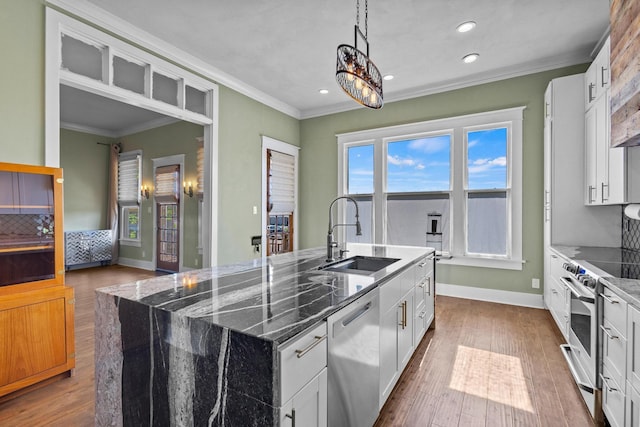 610 W Chestnut St, Denison, TX 75020 - kitchen featuring appliances with stainless steel finishes, a sink, ornamental molding, an island with sink, and tasteful backsplash