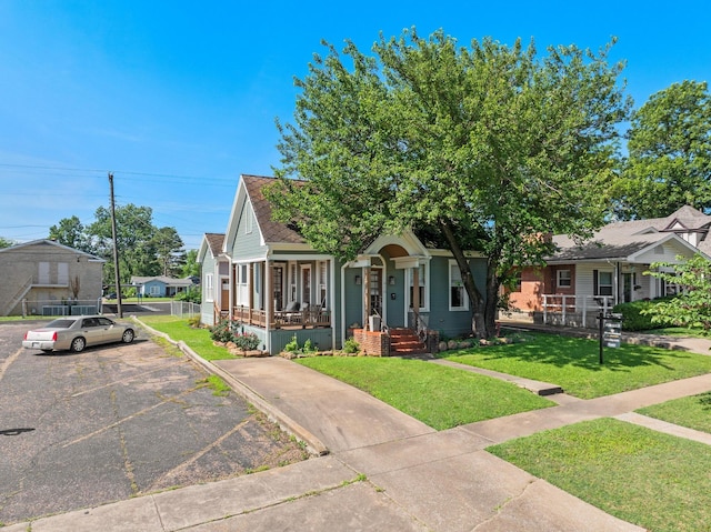 610 W Chestnut St, Denison, TX 75020 - view of property hidden behind natural elements featuring uncovered parking, a front yard, and a porch