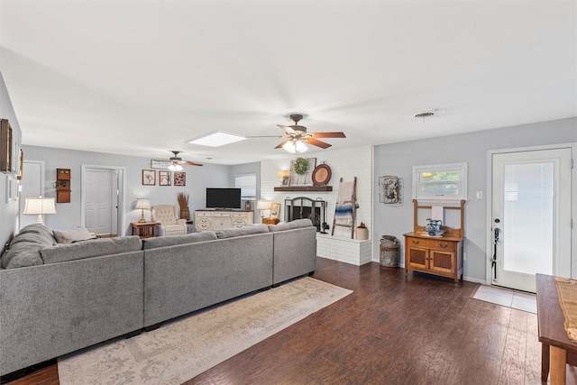 201 Randy Dr, Woodway, TX 76712 - living area with ceiling fan, dark wood-type flooring, a fireplace, and a skylight