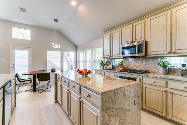 6004 Grand Meadow Ln, Flower Mound, TX 75028 - kitchen with stainless steel appliances, light brown cabinets, vaulted ceiling, backsplash, and a kitchen island