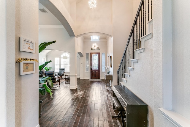 6004 Grand Meadow Ln, Flower Mound, TX 75028 - entryway featuring a high ceiling, dark wood-style flooring, arched walkways, baseboards, and ornamental molding